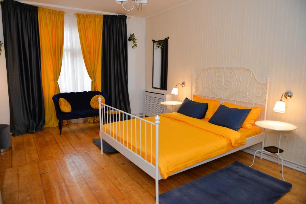 1 dormitorio con 1 cama con sábanas amarillas y almohadas azules en Family Residence, en Sibiu