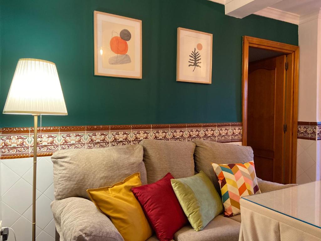 sala de estar con sofá y almohadas coloridas en Casa Hay que Vivir el Momento, en Setenil