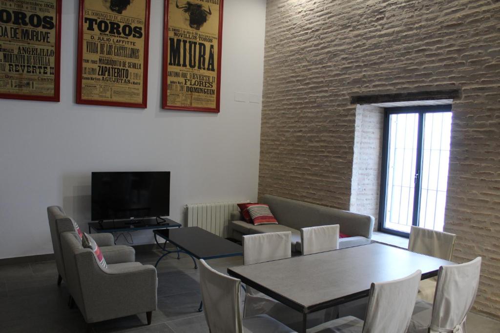 una sala de espera con mesa, sillas y TV en COZY & MODERN APARTMENT HOMBRE DE PIEDRA, en Sevilla