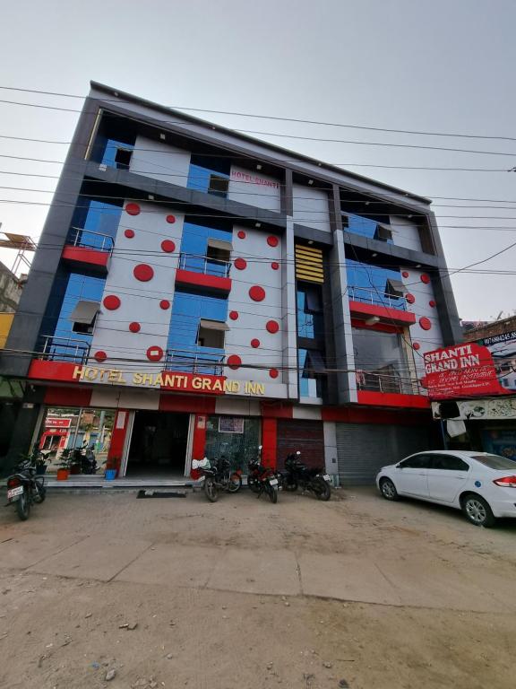 een gebouw waar auto's voor geparkeerd staan bij Hotel Shanti Grand Inn in Gorakhpur