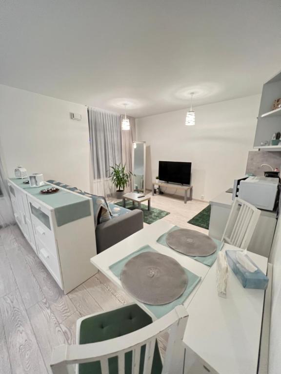 eine Küche und ein Wohnzimmer mit einem Tisch und einem Sofa in der Unterkunft FREE PARKING in garage! New apartment in Karolina Plazza in Prag