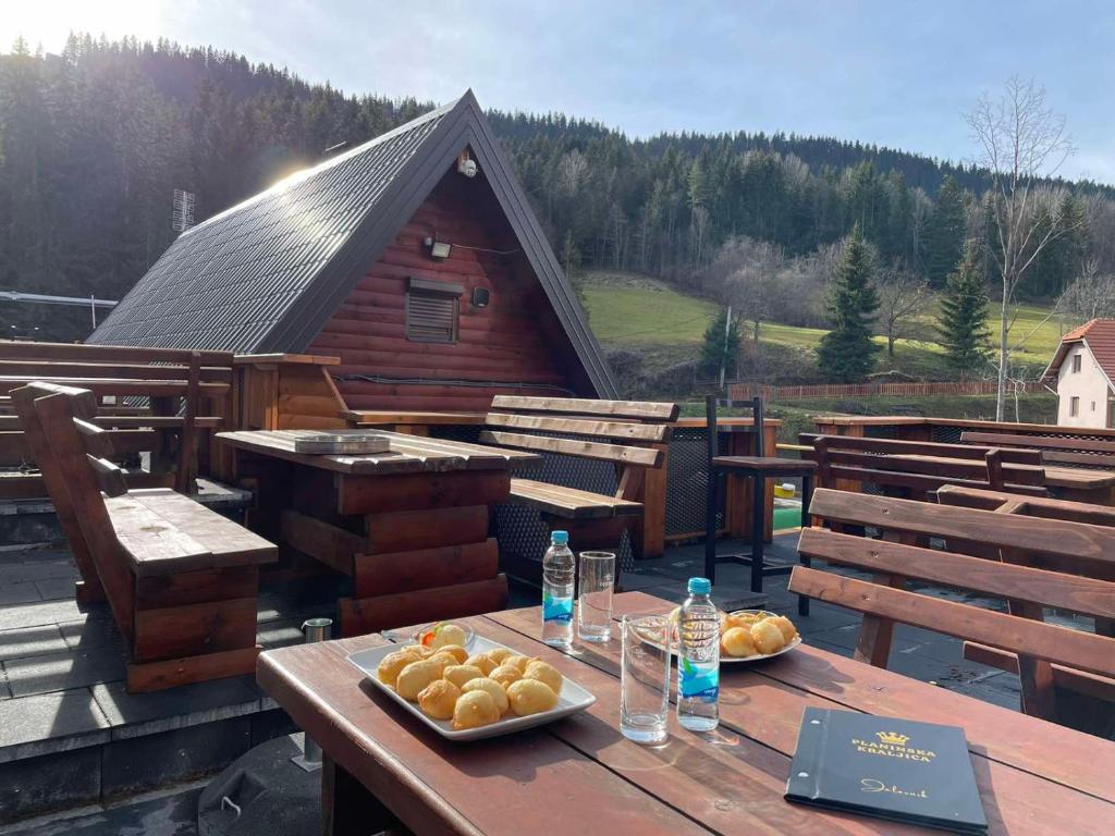a wooden table with a plate of food on a deck at Planinska Kraljica in Gornje Pale