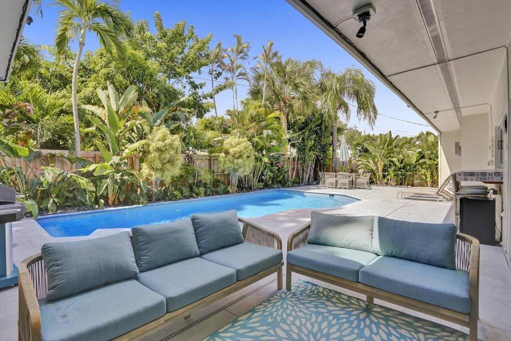 ein Wohnzimmer mit einem Sofa und einem Pool in der Unterkunft Brand New! Heated Pool, Golf Cart, Next to Beach in Fort Lauderdale