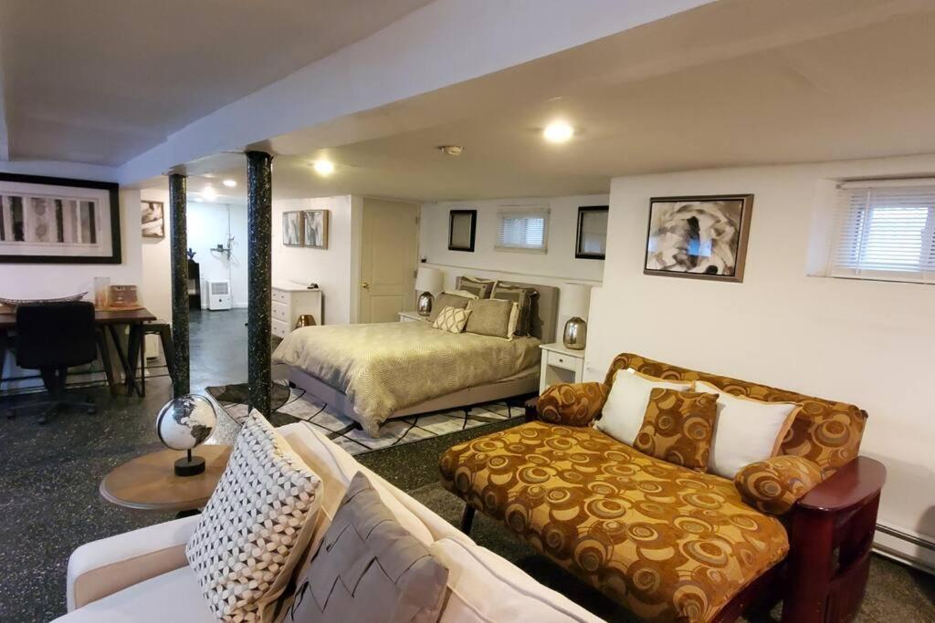 a living room with a bed and a couch at Cozy Studio; Lower Level Unit in Laurelton