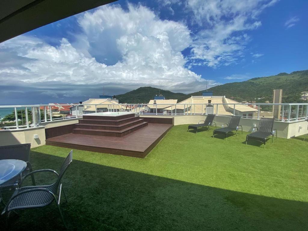 un balcón con sillas y una terraza con vistas al océano. en Studio Brava Holiday, en Florianópolis