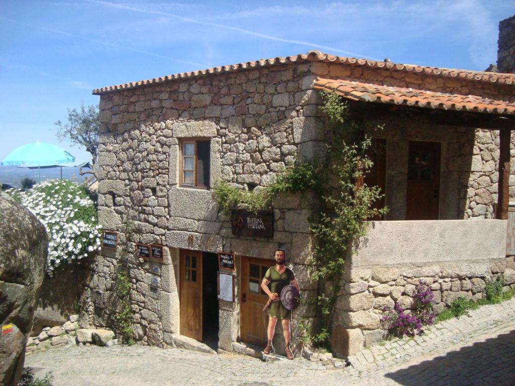 a man standing outside of a stone building at Taverna Lusitana in Monsanto