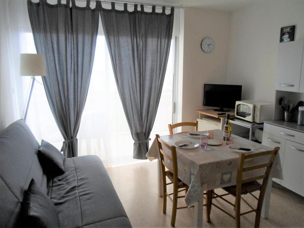 sala de estar con mesa y sofá en Studio Balaruc-les-Bains, 1 pièce, 4 personnes - FR-1-503-25, en Balaruc-les-Bains