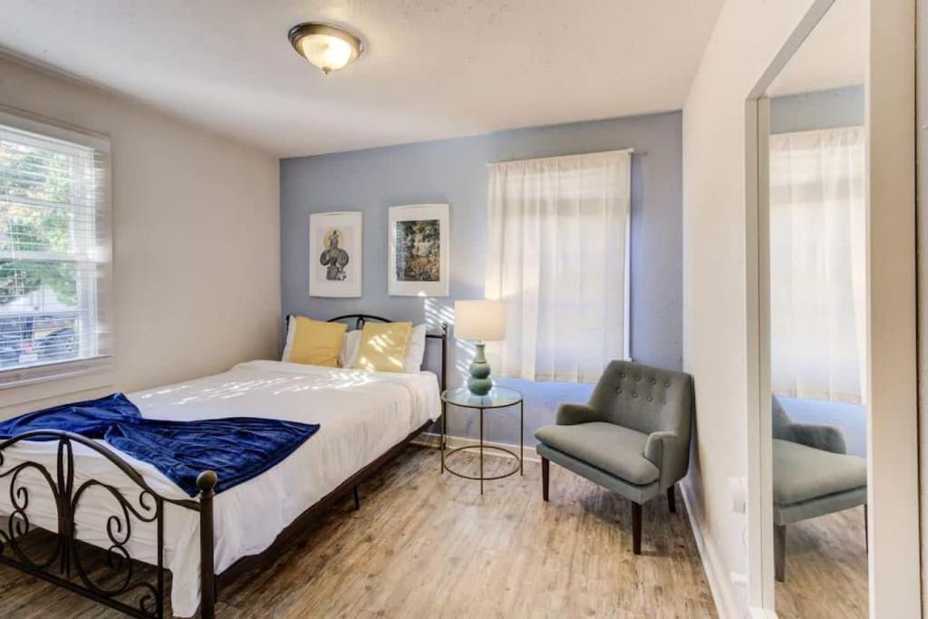 ein Schlafzimmer mit einem Bett und einem Stuhl in der Unterkunft Walk to the Best of Midtown Charming Cottage in Memphis