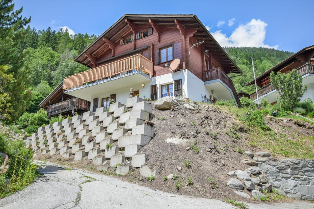 a house on a hill with a retaining wall at Reste Fidèle Duplex in Fiesch
