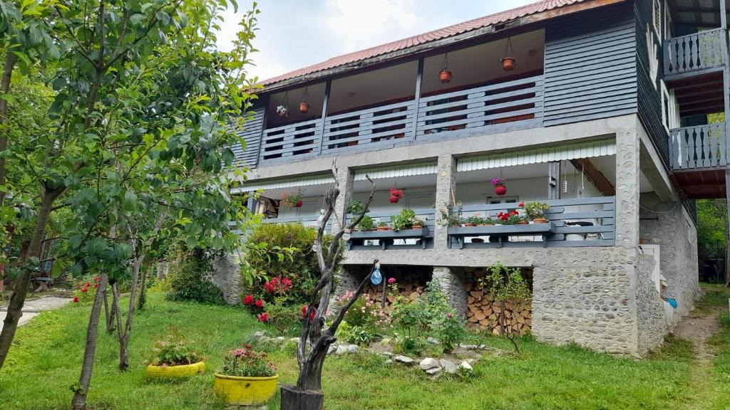 a building with flowers on the side of it at Pensiunea Poiana Soarelui in Ciungetu