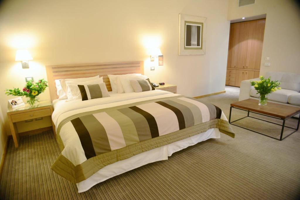 a large bedroom with a large bed and a couch at Hotel Casino Talca in Talca
