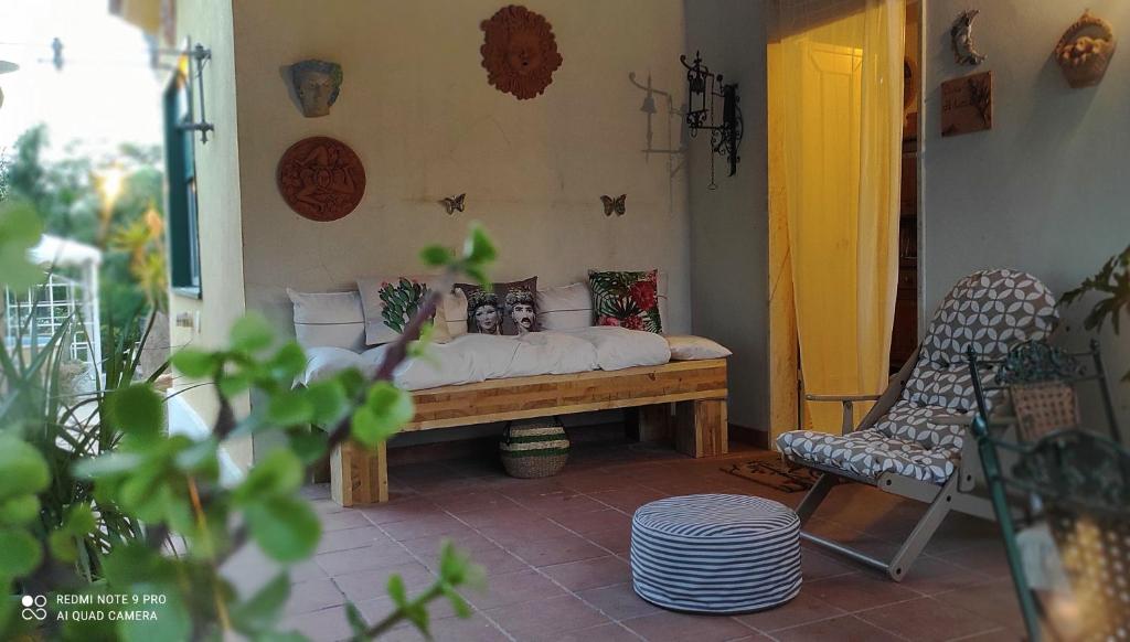 a room with a bed with pillows and a chair at DONNA CATERINA HOUSE in Pietraperzia