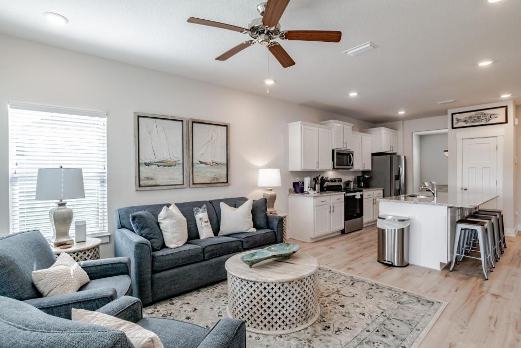 a living room with blue couches and a kitchen at Serenity Island Treasure At 7868 Evening Glow Drive in Pensacola