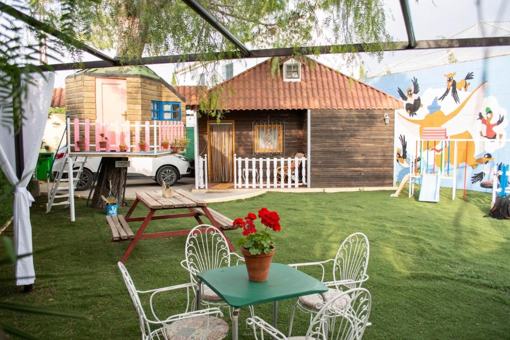 un patio con una mesa y sillas y una casa en Bungalow Perotonar Ideal Para Familia Con Niños en La Puebla de Cazalla