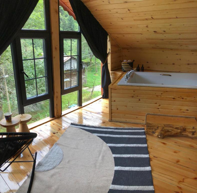 a large room with a tub in a log cabin at Zilkale Butik Otel in Çamlıhemşin