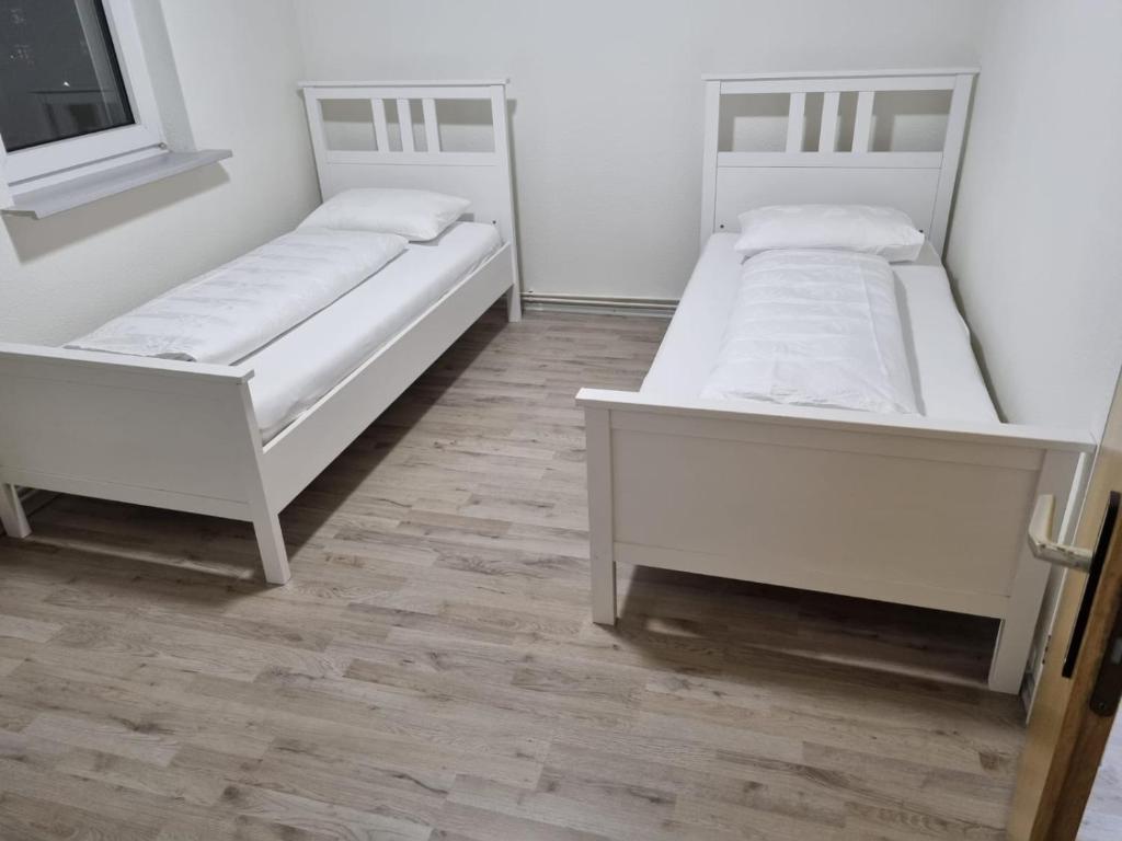 two beds in a room with wooden floors at Ferienwohnung Kassel Zentral in Kassel