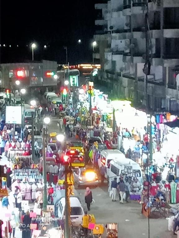 a crowd of people on a busy city street at night at Aatun flat in Miami families only in Alexandria