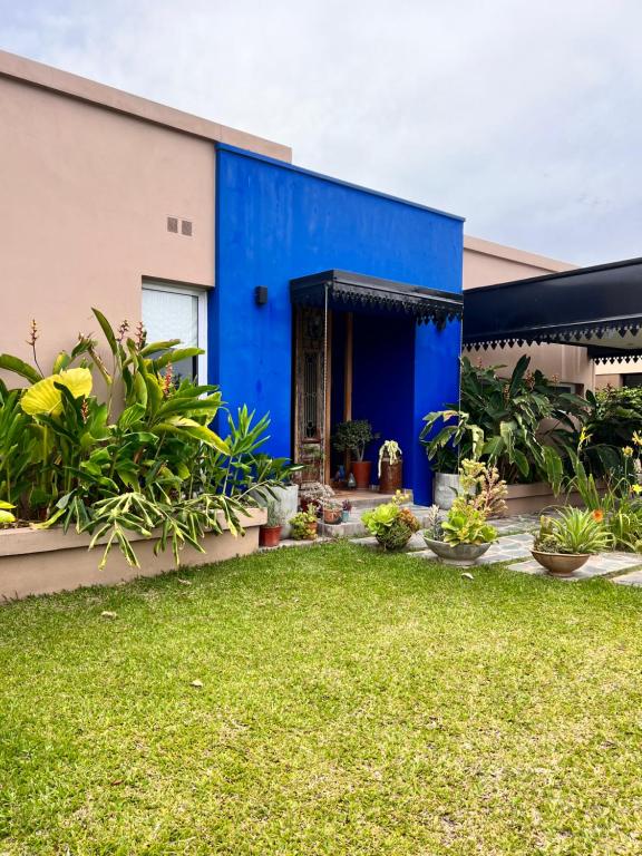 un bâtiment bleu avec des plantes dans une cour dans l'établissement Casa Azul en Barrio Privado, à San Pablo
