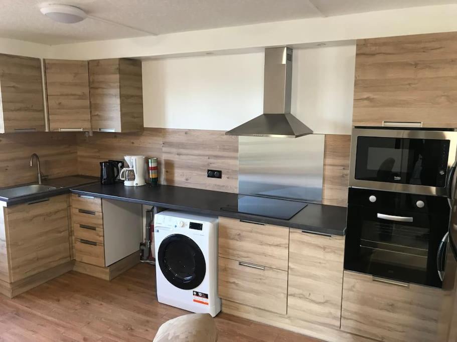 a kitchen with a washer and a microwave at Le p’tit Bragard in Saint-Dizier