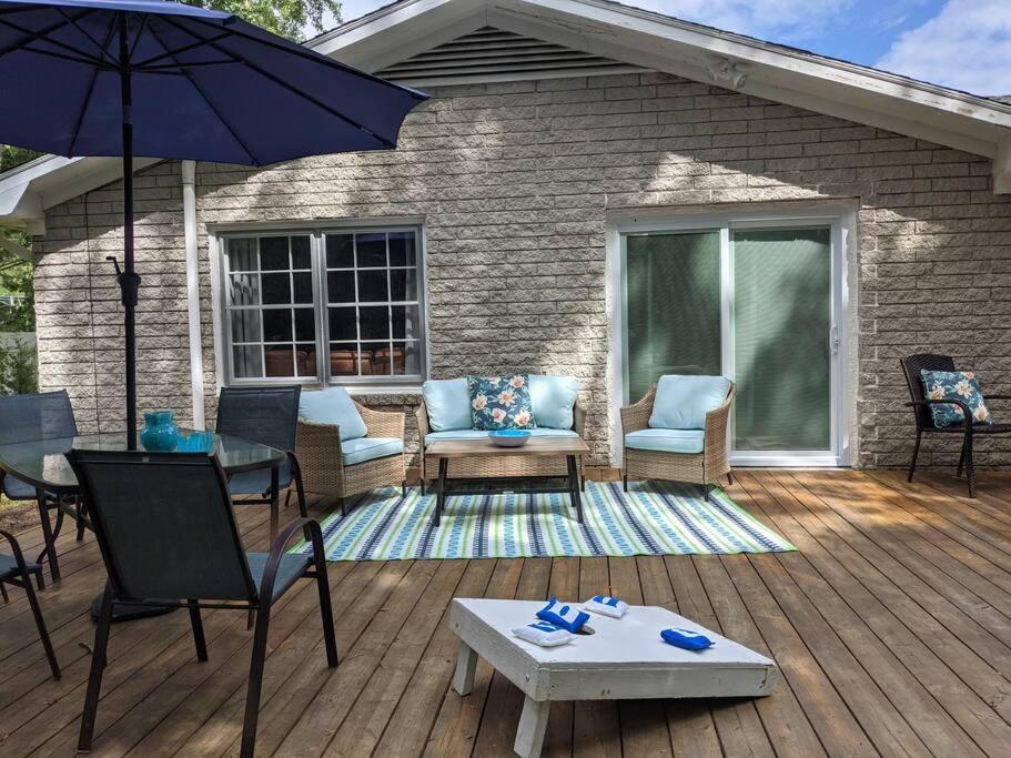 patio con sedie, tavolo e ombrellone di Wilmington Family Vacation Home a Wilmington