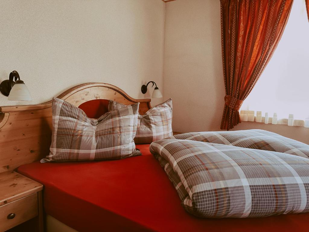 a bedroom with a bed with pillows and a window at Appartamenti Lumaca in Livigno