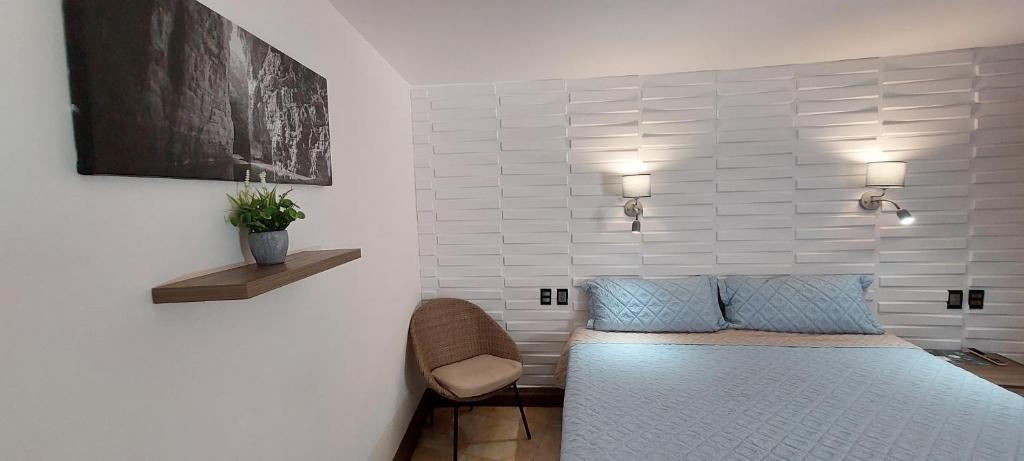 1 dormitorio con 1 cama y 1 silla en Palmareca Inn-Suites-Studio, en Tuxtla Gutiérrez