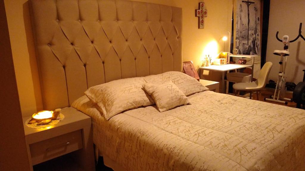 - une chambre avec un grand lit et un bureau dans l'établissement Habitación matrimonial con cama y sofá para cuatro personas, à Tlazcalancingo