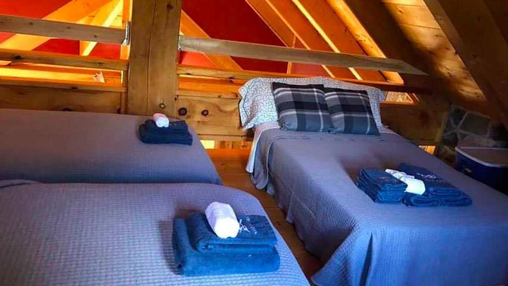 a bedroom with two beds in a attic at Le Refuge de mon père in Sacré-Coeur-Saguenay