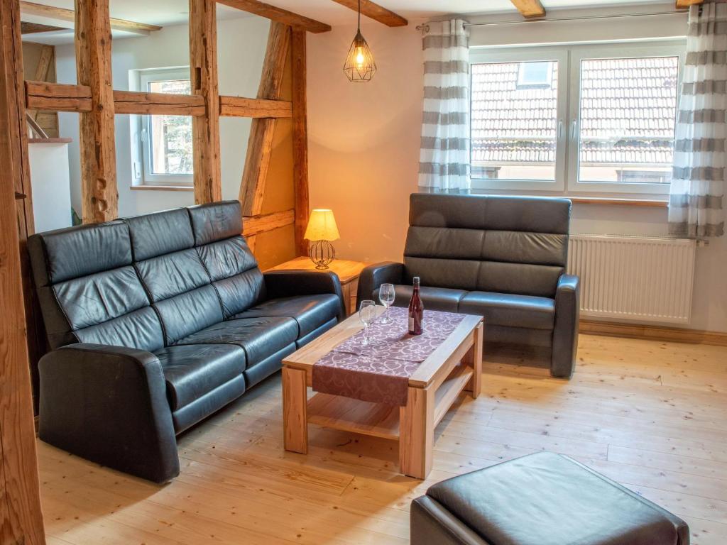 a living room with two leather couches and a coffee table at Kleine Bergstraße 2 - Haus 1 in Tanne