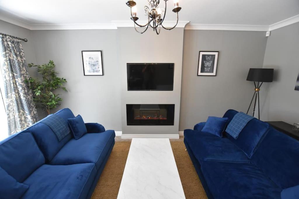 a living room with two blue couches and a fireplace at The Nutshell, a Luxury mews property! in Southport