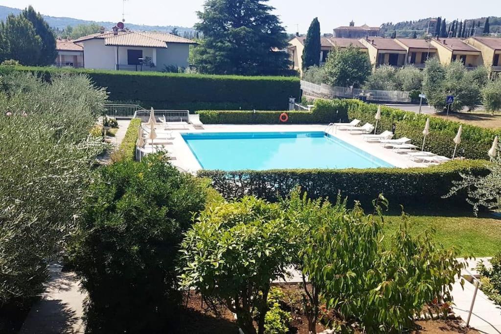 una piscina en un jardín con árboles y arbustos en Morgan's oasis, en San Felice del Benaco