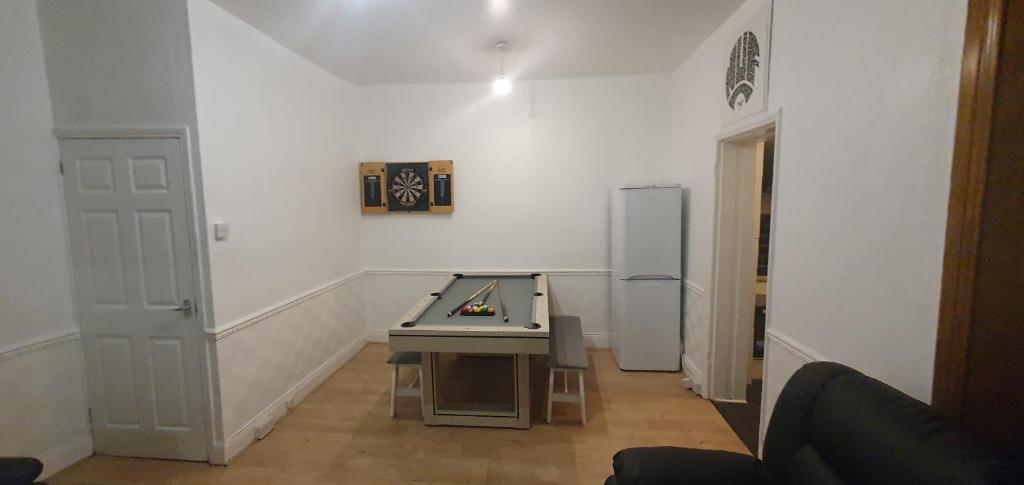 a room with a ping pong table and a refrigerator at Hustlers inn apartment in Newcastle upon Tyne