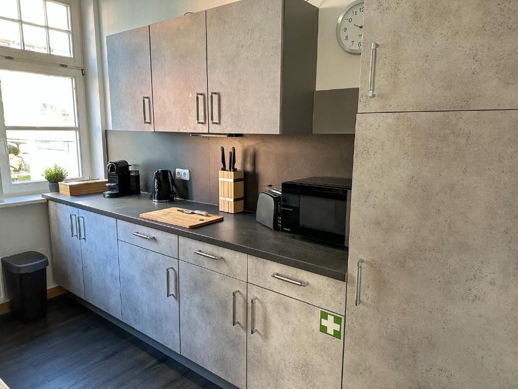 a kitchen with stainless steel cabinets and a refrigerator at bee Design Apartment + Zentral + Küche + Parken in Wetzlar