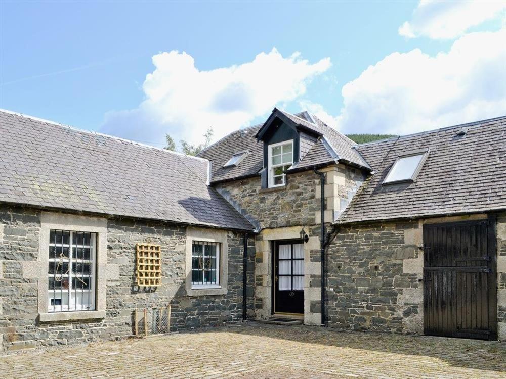 an old stone house with a large driveway at Manyleith Rig Cottage in Polmood