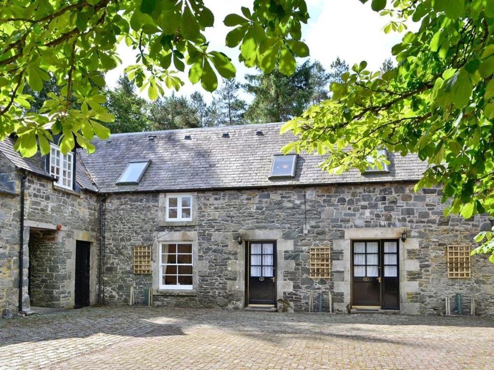 an old stone building with two doors and windows at Lategillan Cottage in Polmood