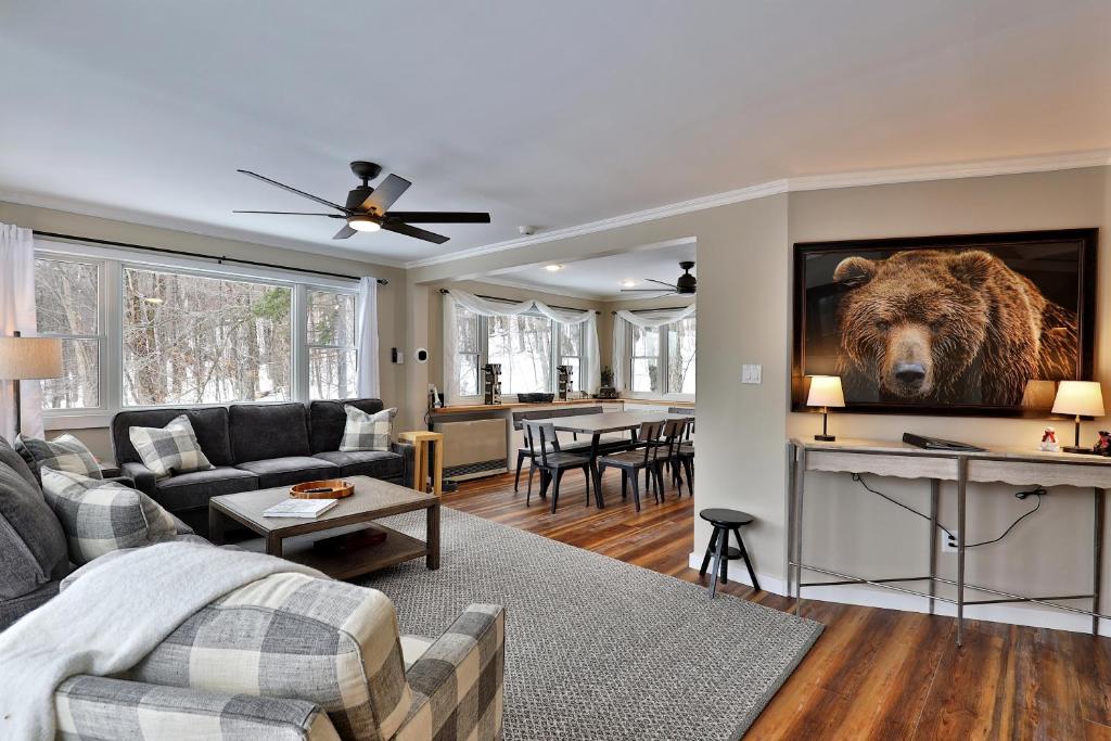 ein Wohnzimmer mit einem Bären an der Wand in der Unterkunft Premium 5 bedroom, pet friendly private home with hot tub 3 miles from the Skyship Bear in Killington
