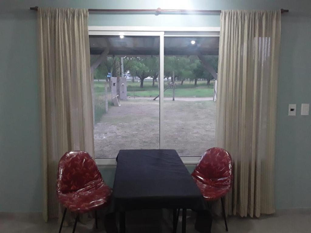 mesa de comedor y 2 sillas frente a una ventana en daniela en Santa Teresita