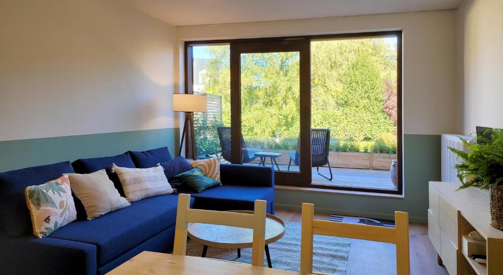 ein Wohnzimmer mit einem blauen Sofa und einem Tisch in der Unterkunft oYo apartments in Kortrijk