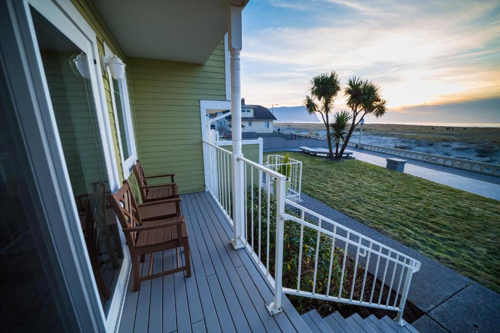 a porch with two chairs and a view of the beach at Inn of the Four Winds Seaside Oceanfront in Seaside