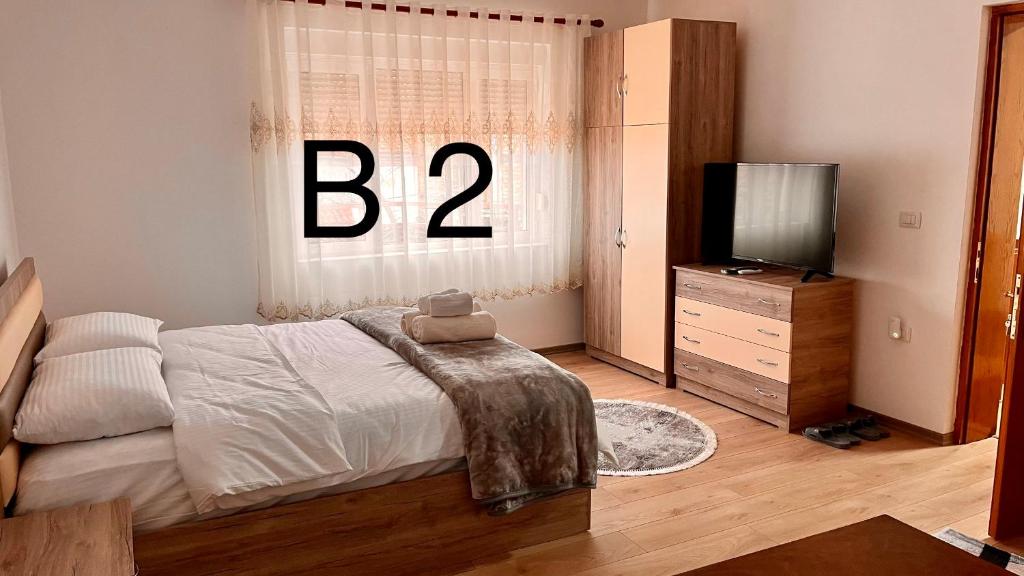 Un dormitorio con una cama y una ventana con la letra b en Dritëza, en Korçë