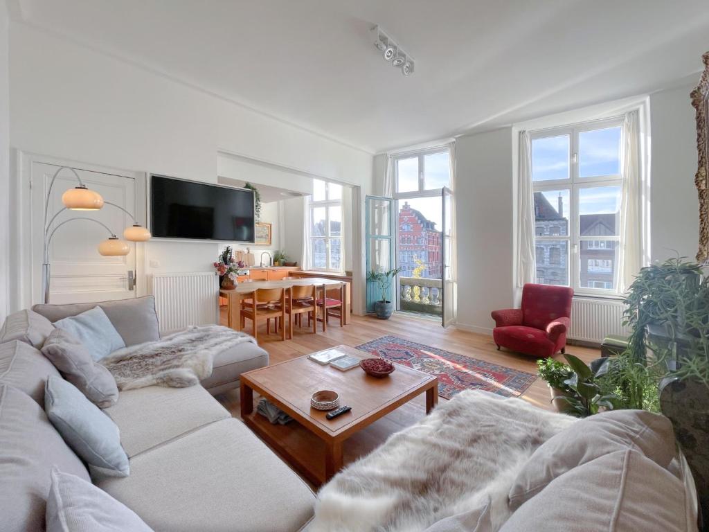 a living room with a couch and a table at Appartement spacieux & calme avec vue sur l'Escaut in Tournai