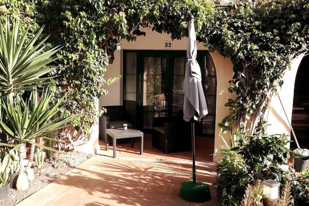 a patio with an umbrella in the middle of a house at Premium Duplex Castillo Mar 32 in Caleta De Fuste