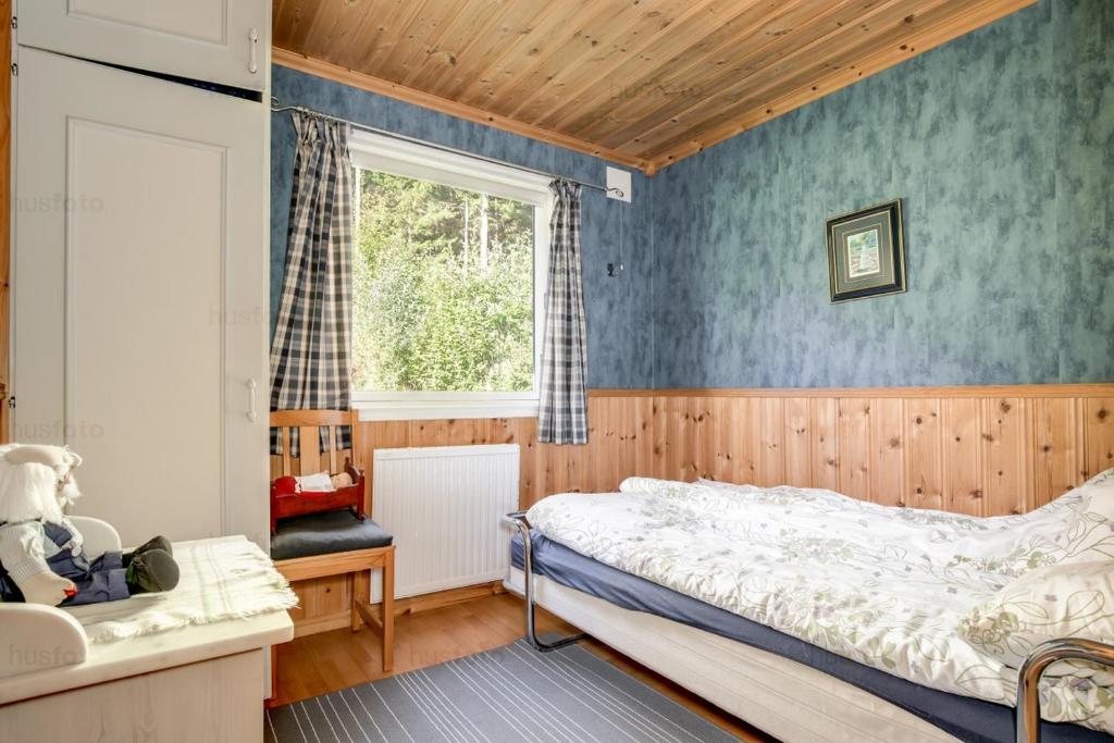 1 dormitorio con cama y ventana en Sunne Stugcenter 12, en Gräsmark