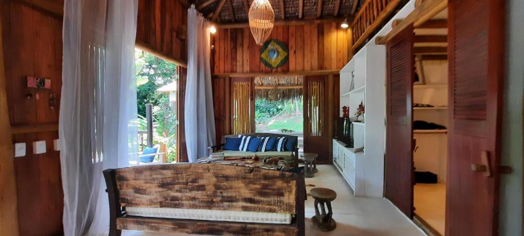 a living room with a couch and a chair in it at Trancoso Jungle Lodge in Trancoso