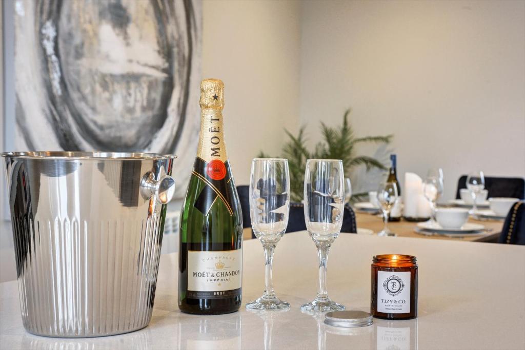 una botella de champán y dos copas de vino en una mesa en The Penthouse - Allocated Parking with City Views en Ripon