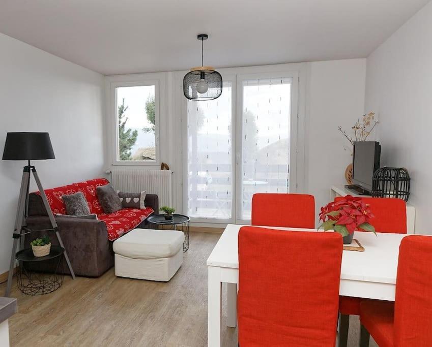 a living room with red chairs and a couch at Le balcon cerdan in Font-Romeu-Odeillo-Via