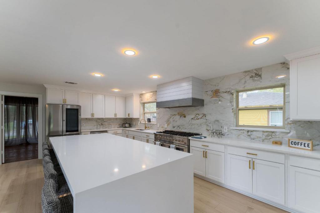 a white kitchen with a large white counter top at The Magnolia House- One of a kind home in the city in Arlington