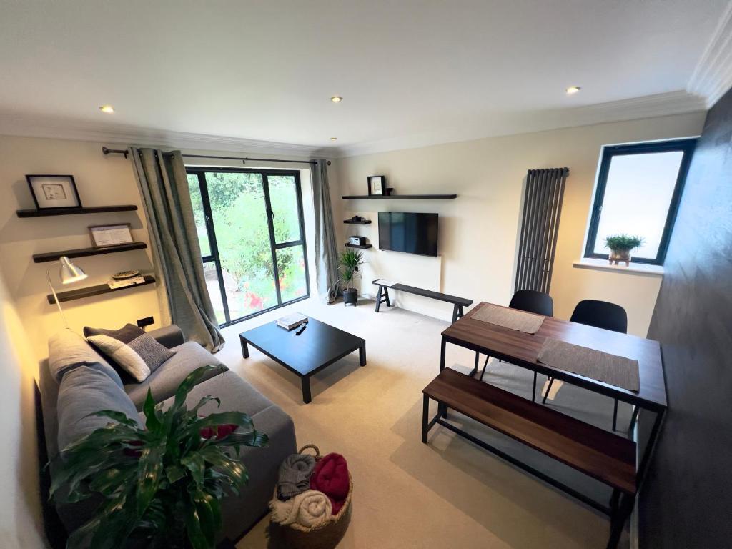 un soggiorno con divano e tavolo di Modern and cozy 2-guest flat with gated parking a Kingston upon Thames