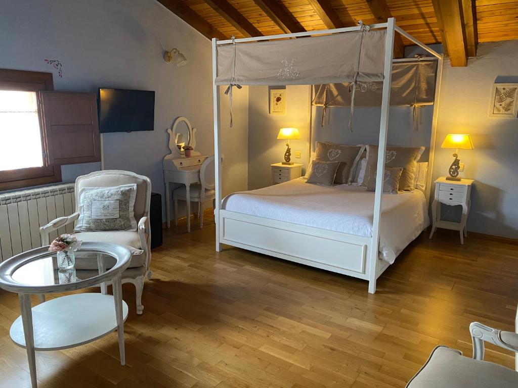a bedroom with a canopy bed and a table and a chair at El Balcón De Alboreca in Alboreca