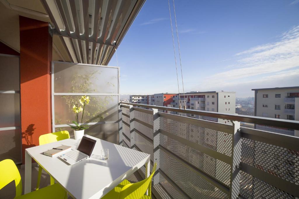 a balcony with a table and a laptop on it at Aurum Aparthotels Bicocca in Milan